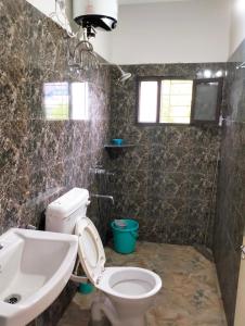 a bathroom with a toilet and a sink at Yangzom Homez in Siliguri