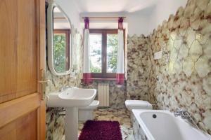 a bathroom with a sink and two toilets and a tub at La Pennica bnb in Pontremoli