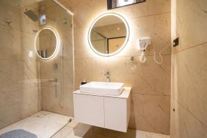 a bathroom with a sink and a shower and a mirror at Freshup Hotel in Tirupati +34 photos