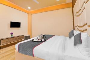 a hotel room with a bed and a flat screen tv at Super Collection O Hotel Blueline in Juhi Bari +31 photos