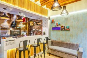 a bar with chairs and a couch in a room at Super Collection O Hotel Blueline in Juhi Bari
