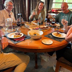 a group of people sitting around a table with food at Central Otago Hydeaway in Hyde