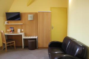 een wachtkamer met een bureau en een stoel bij The Originals City, Hôtel Continental, Poitiers (Inter-Hotel) in Poitiers