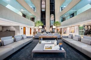 a lobby with couches and tables in a building at Meliá Brasil 21 in Brasília