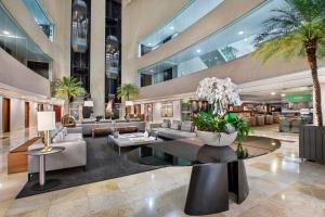 a lobby of a building with palm trees at Meliá Brasil 21 in Brasília +208 photos