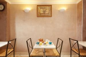 tavolo con sedie e tavolo bianco con cibo di Hôtel Viator a Parigi