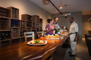 a group of people standing around a table in a wine cellar at Safarihoek Lodge in Kamanjab