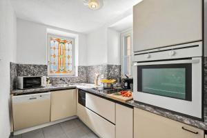 a kitchen with white appliances and a window at Charm Apartments Aldesago in Aldesago