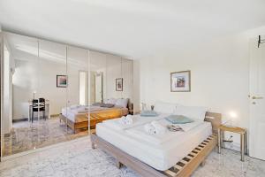 a bedroom with two beds and a mirror at Charm Apartments Aldesago in Aldesago