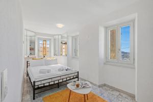 a white room with a bed and a table at Charm Apartments Aldesago in Aldesago +54 photos