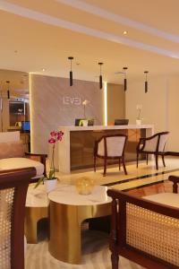 a living room with tables and chairs and a counter at Meliá Lima in Lima