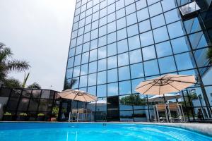 a pool with umbrellas in front of a building at Meliá Lima in Lima