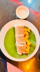 a plate of food with a piece of cake and fruit at Wonder Stay in Jaffna