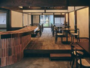 a restaurant with tables and chairs in a room at KAZENO Kurayoshi in Kurayoshi