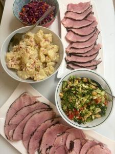 a table topped with different types of meats and salad at Central Otago Hydeaway in Hyde