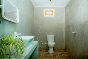a bathroom with a white toilet and a sink at Beach Lovers Tiny House in Nilaveli +19 photos