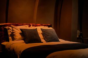 a bed with black and white pillows on it at Valahara Eco-Luxury Camp in Antsirabe