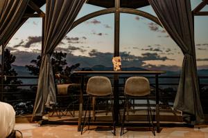 a table and two chairs in front of a window at Valahara Eco-Luxury Camp in Antsirabe
