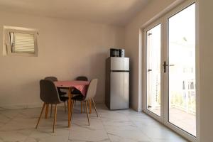 a kitchen with a table with chairs and a refrigerator at Starfish Apartments in Sutivan