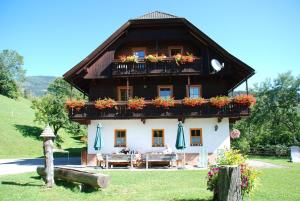 a house with a balcony and a table in front of it at Ferienwohnung Lahnerhof in Arriach