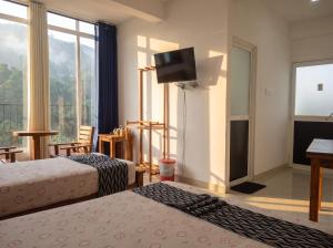 a hotel room with two beds and a flat screen tv at Top Mountain Resort in Diyatalawa