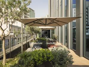 a patio with tables and an umbrella on a building at Hyatt Centric Milan Centrale in Milan