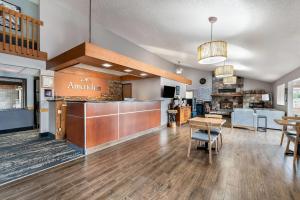 a lobby with a restaurant with a table and chairs at AmericInn by Wyndham Cloquet in Cloquet