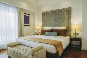 a bedroom with a large bed and a couch at Villa Rosa Kempinski in Nairobi