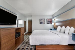 a hotel room with a bed and a flat screen tv at AmericInn by Wyndham Cloquet in Cloquet
