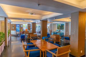 a restaurant with wooden tables and blue chairs at Kuta Beach Hotel in Kuta +33 photos