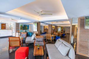 a living room with chairs and a couch and tables at Kuta Beach Hotel in Kuta