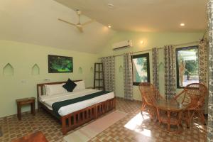 a bedroom with a bed and a table and chairs at Sariska Forest Trail in Rāmsinghpura
