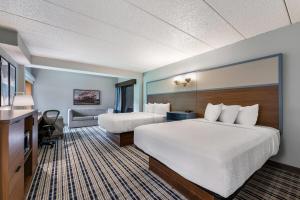 a hotel room with two beds and a couch at AmericInn by Wyndham Cloquet in Cloquet +69 photos