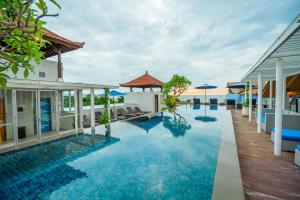 a pool at a resort with the ocean in the background at Kuta Beach Hotel in Kuta