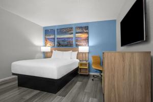 a bedroom with a bed and a tv and a desk at Days Inn by Wyndham Gatesville in Gatesville
