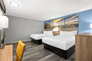 a hotel room with two beds and a desk at Days Inn by Wyndham Gatesville in Gatesville +18 photos