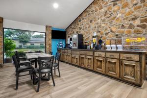 a kitchen with a stone wall and a table and chairs at Days Inn by Wyndham Gatesville in Gatesville