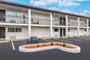 a building with a bench in a parking lot at Days Inn by Wyndham Gatesville in Gatesville