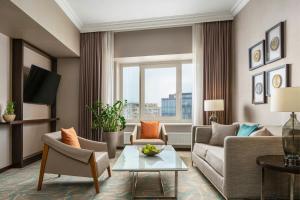 a living room with a couch and a table at JW Marriott Bucharest Grand Hotel in Bucharest