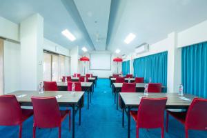 a dining room with tables and red chairs at Kuta Beach Hotel in Kuta