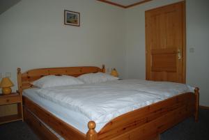 a bedroom with a wooden bed and a wooden door at Ferienwohnung Lahnerhof in Arriach