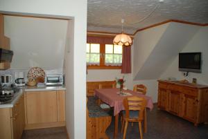 eine Küche und ein Esszimmer mit einem Tisch und Stühlen in der Unterkunft Ferienwohnung Lahnerhof in Arriach