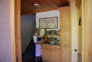 Eine Frau, die an einer Theke in einer Küche steht. in der Unterkunft Ferienwohnung Lahnerhof in Arriach