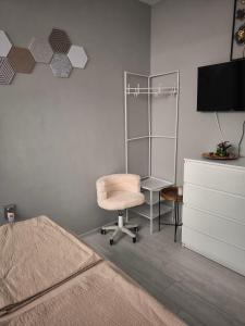 a bedroom with a bed and a chair and a desk at Апартамент Туида 2 in Sliven
