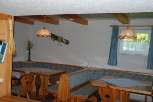 a dining room with two tables and two chairs at Ferienwohnung Lahnerhof in Arriach
