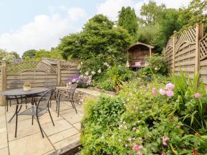 a patio with a table and chairs in a garden at West View in Milnthorpe