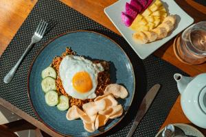 a plate of food with an egg on a table at The Kaci Penida By Bali Cabin in Nusa Penida +19 photos