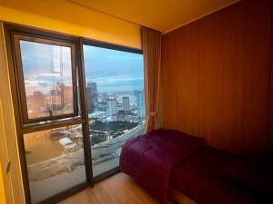 a bedroom with a large window with a view of a city at Vue Aston in Phnom Penh