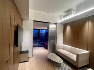 a living room with a white couch and a tv at Vue Aston in Phnom Penh