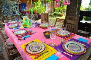 サントマリー・ド・ラメールにあるMazet du Maréchal Ferrantのピンクのテーブル(皿、ワイングラス付)